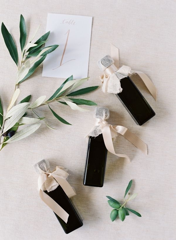 In questa foto bomboniere di nozze in stile minimal composte da bottigliette di colore nero con nastro di colore beige