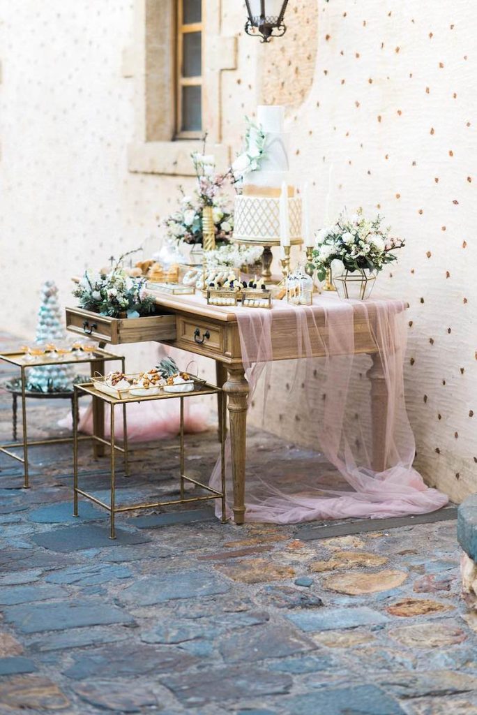 In questa foto un mobile antico usato come angolo dei dolci di un matrimonio shabby chic