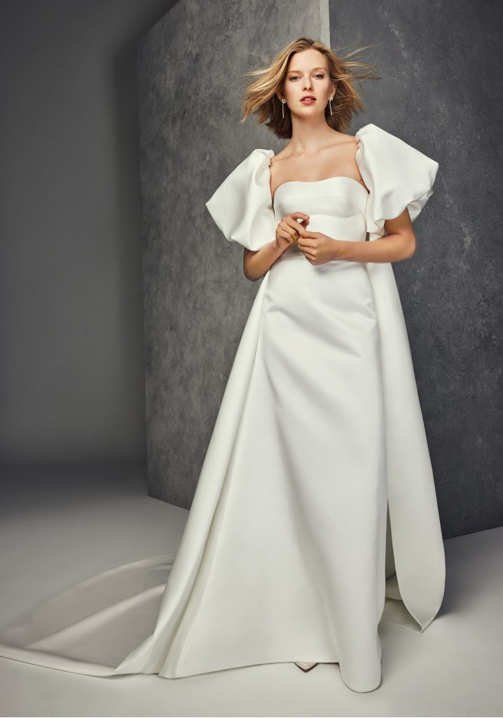 In questa foto una modella indossa un abito da sposa trasformabile 2023 di Jesus Peiro