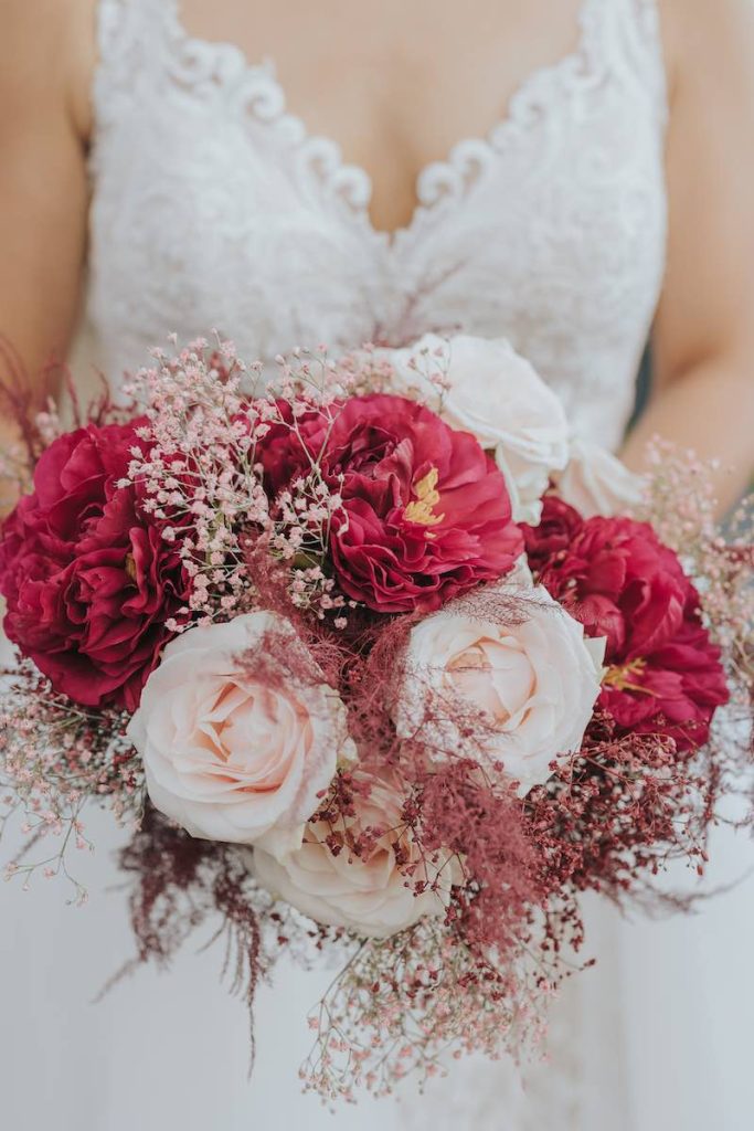 In questa foto un bouquet da sposa con fiori nel colore matrimonio 2023 Viva Magenta abbinati a fiori di colore rosa