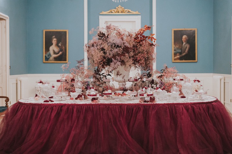 In questa foto un tavolo per matrimonio decorato con gypsophila di colore rosa e drappi di tulle nel colore del matrimonio 2023 Viva Magenta