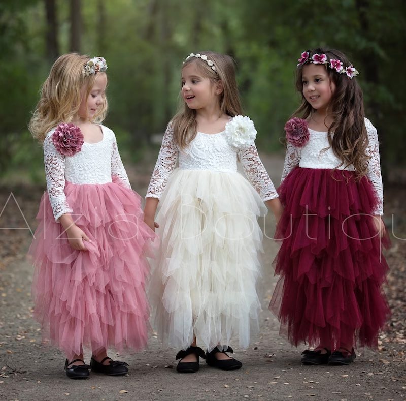 In questa foto tre flower girl con abiti in tulle nei colori Viva Magenta, rosa e bianco