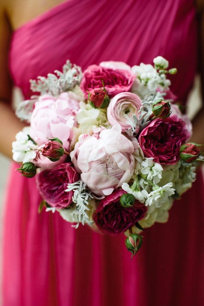 In questa foto un bouquet da sposa con fiori nel colore matrimonio 2023 Viva Magenta abbinati a fiori di colore rosa