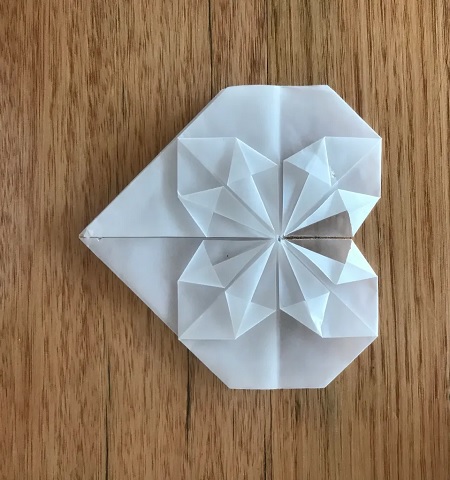 In questa foto, una partecipazione matrimonio origami bianca a forma di cuore 