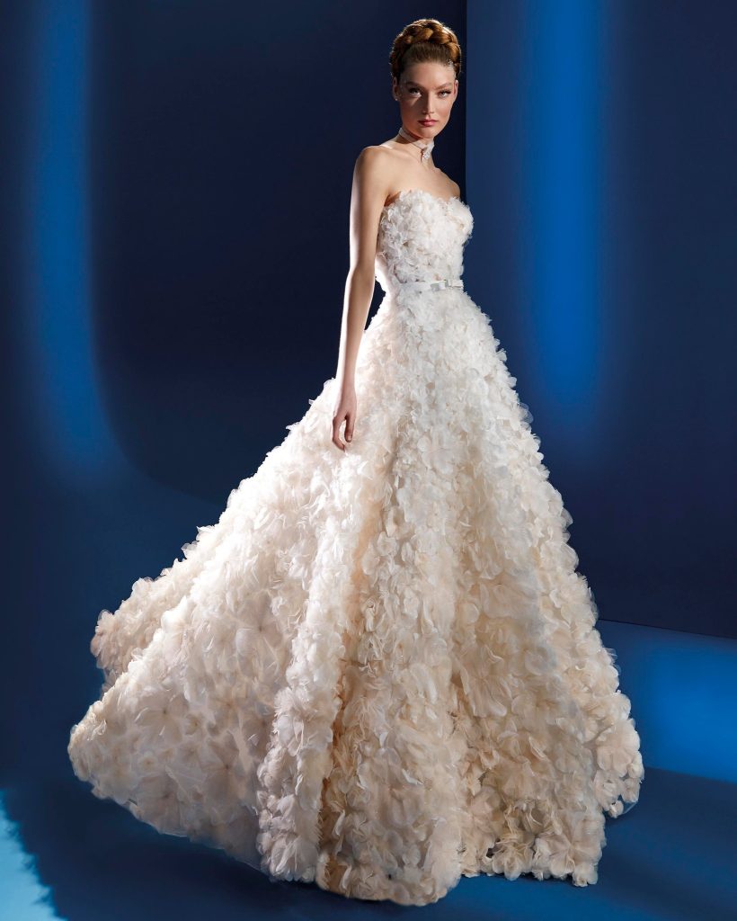 In questa foto la modella indossa un abito da sposa a principessa 2023 con fiori tridimensionali Atelier Pronovias 