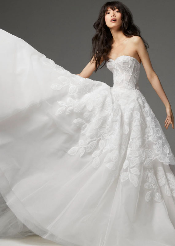 In questa foto la modella indossa un abito da sposa con gonna ampia di tulel e fiori Ines Di Santo