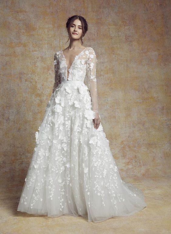 In questa foto la modella indossa un abito da sposa con gonna di tulle e fiori tridimensionali 