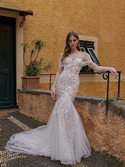 In questa foto la modella indossa un abito da sposa a sirena 2023 con fiori tridimensional e maniche a sbuffo Michela Ferriero