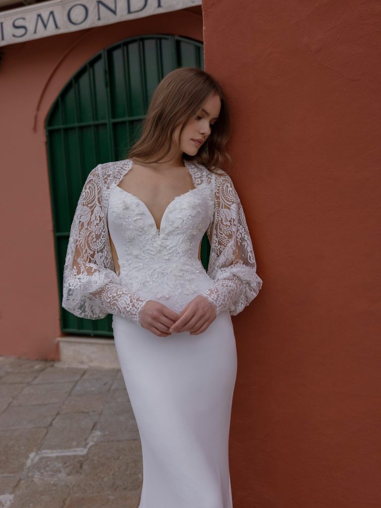 In questa foto la modella indossa un abito da sposa a sirena con maniche di pizzo Michela Ferriero