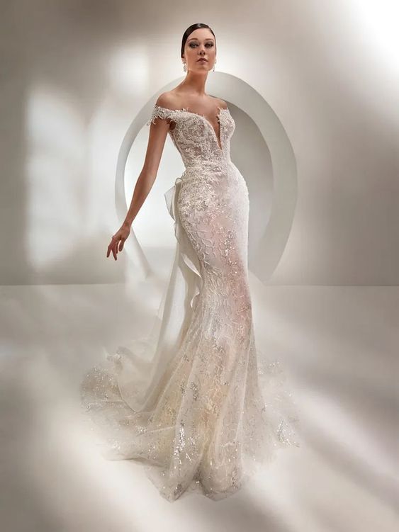In questa foto la modella indossa un abito da sposa a sirena 2023 di pizzo Nicole Milano