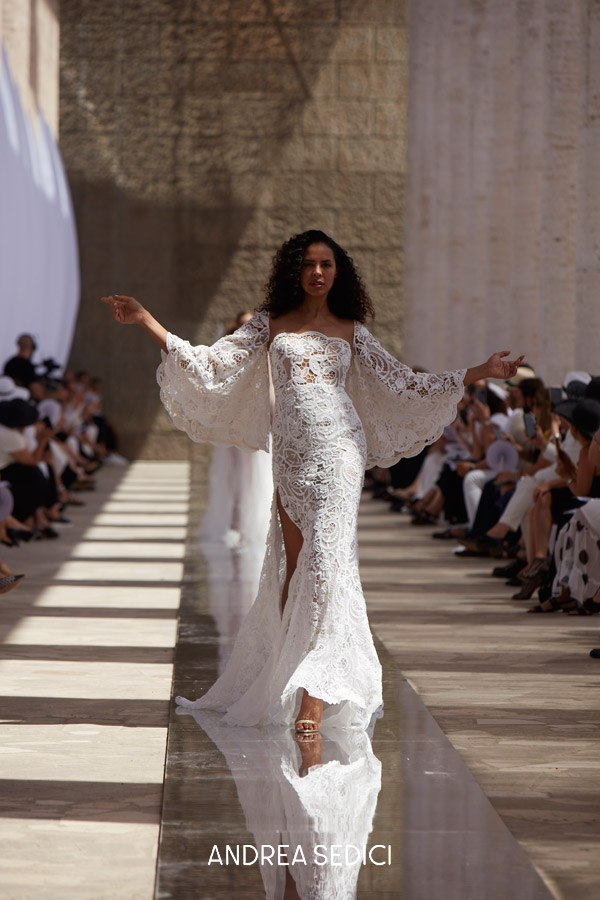 In questa foto la modella indossa un abito da sposa a sirena con maniche di pizzo Andrea Sedici