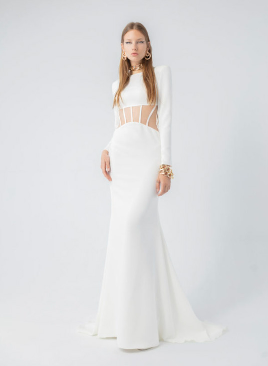 In questa foto la modella indossa un abtio da sposa moderno con taglio cut out a sirena e maniche lunghe 
