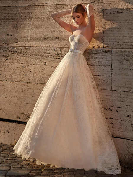 In questa foto la modella indossa un abito da sposa ampio di pizzo Nicole Milano