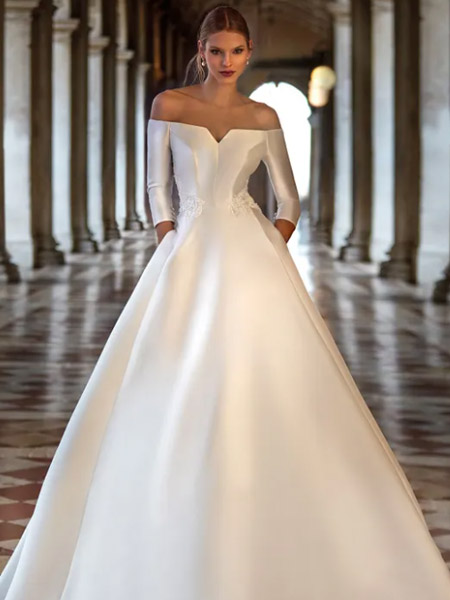 In questa foto la modella indossa un abito da sposa con gonna ampia in mikado Nicole Milano