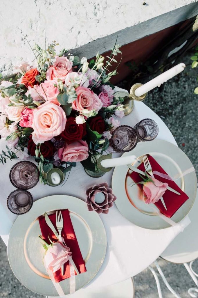 In questa foto un tavolo per matrimonio con tovaglioli e rose nel colore matrimonio 2023 Viva Magenta abbinato a rose di colore rosa 