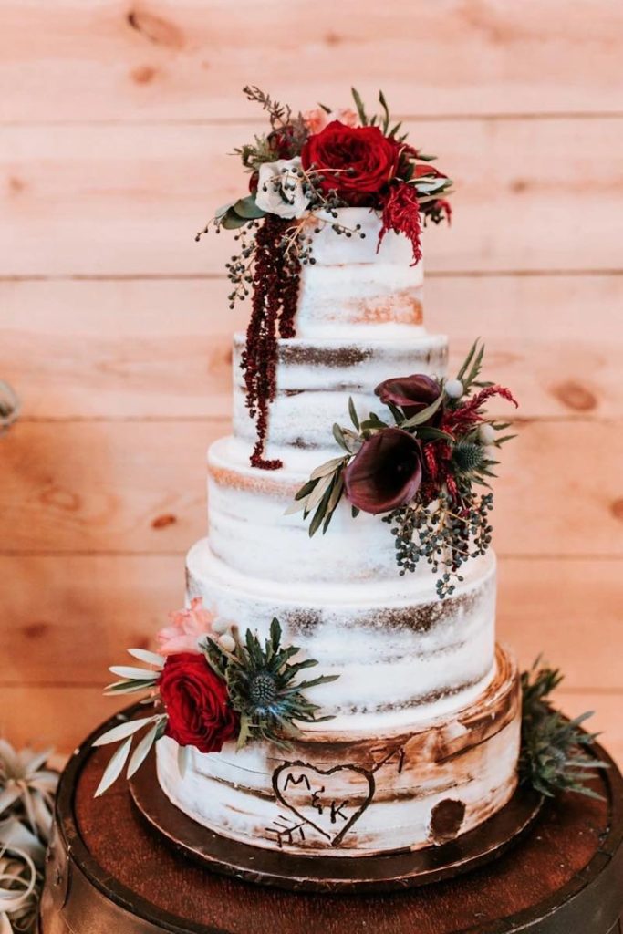In questa foto una naked cake a cinque piani posizionata decorata con fiori e pennellate nel colore Viva Magenta
