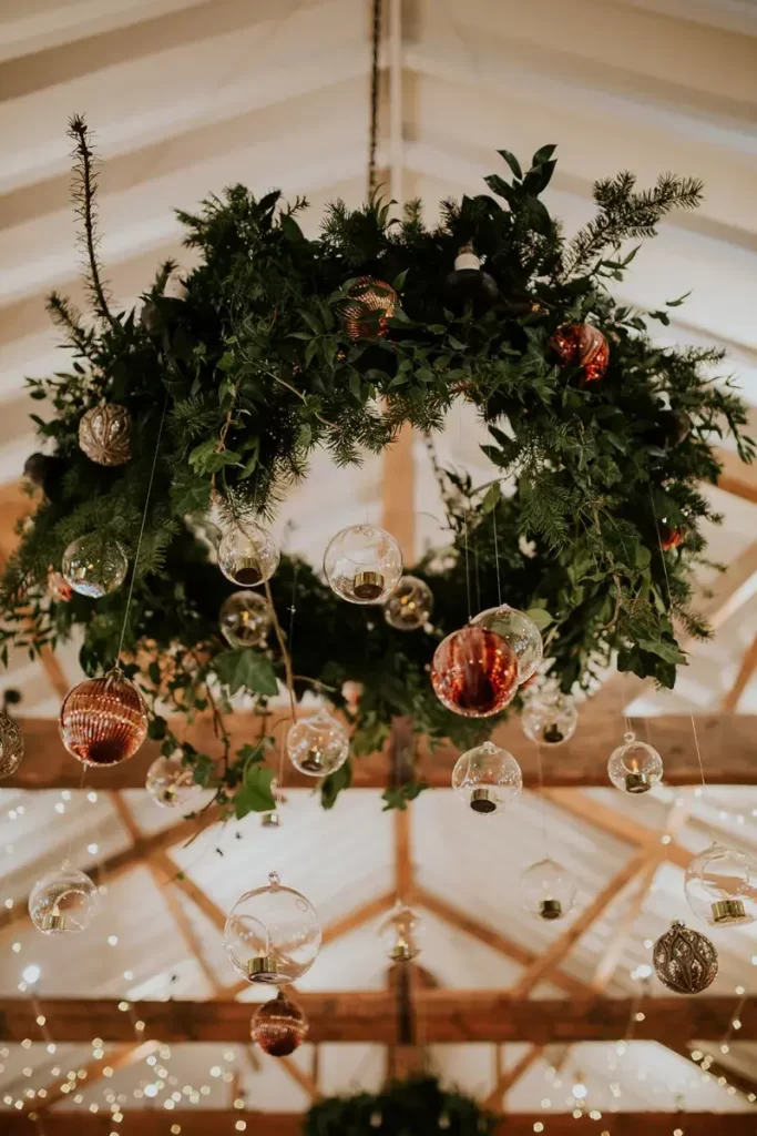 In questa foto una ghirlanda di pino per matrimonio a tema Natale decorata con palline di vetro trasparente e di colore rosso