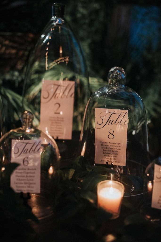 In questa foto un tableau per matrimonio a tema Natale con card posizionate all'interno di campane di vetro