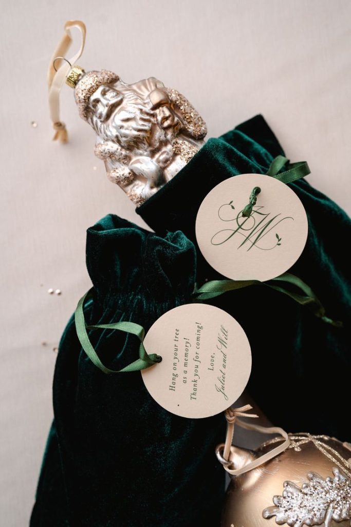 In questa foto una bomboniera per matrimonio a tema Natale: una decorazione natalizia a forma di Babbo Natale d'argento racchiuso in un sacchetto di velluto di colore verde