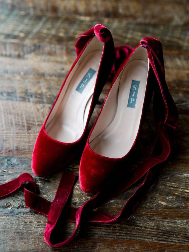 In questa foto scarpe da sposa a Natale di velluto di colore rosso con lacci