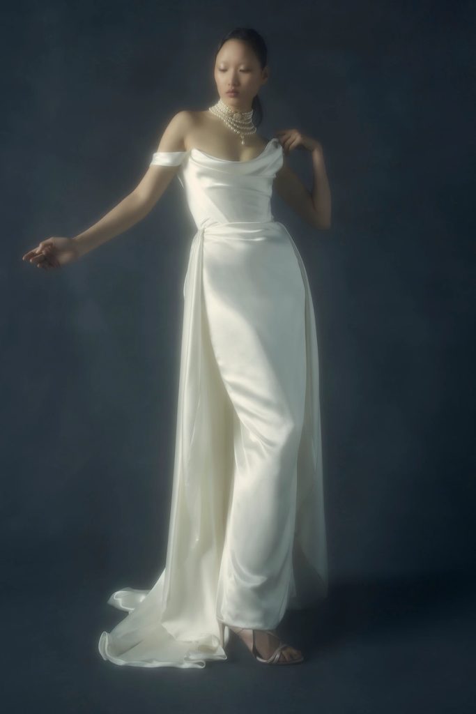In questa foto una modella posa indossando un abito da sposa a sirena con gonna removibile di Vivienne Westwood