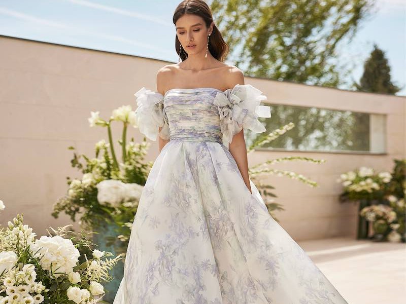 In questa foto una modella indossa un abito da sposa in organza stampata e ruches sulle maniche di Rosa Clará da usare come secondo abito da sposa