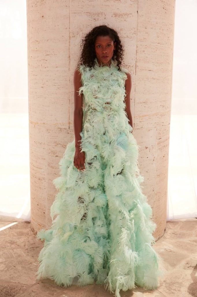 In questa foto una modella indossa un abito da sposa colorato con piume all over di colore verde mela di Andrea Sedici da usare come secondo abito da sposa