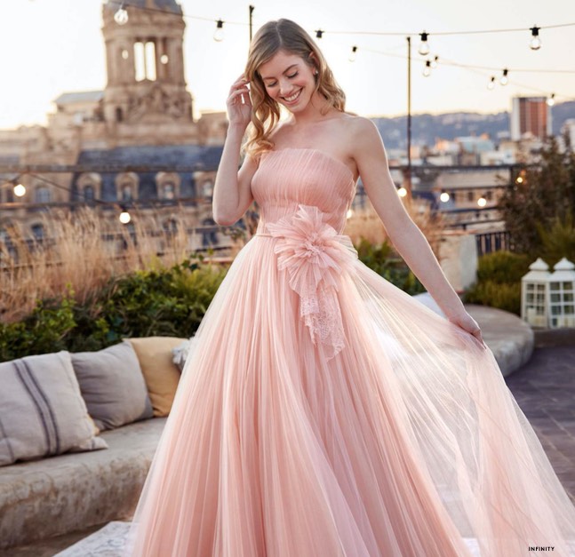 In questa foto una modella indossa un abito da sposa rosa in tulle di seta di White One con fiore 3D in vita da usare come secondo abito da sposa