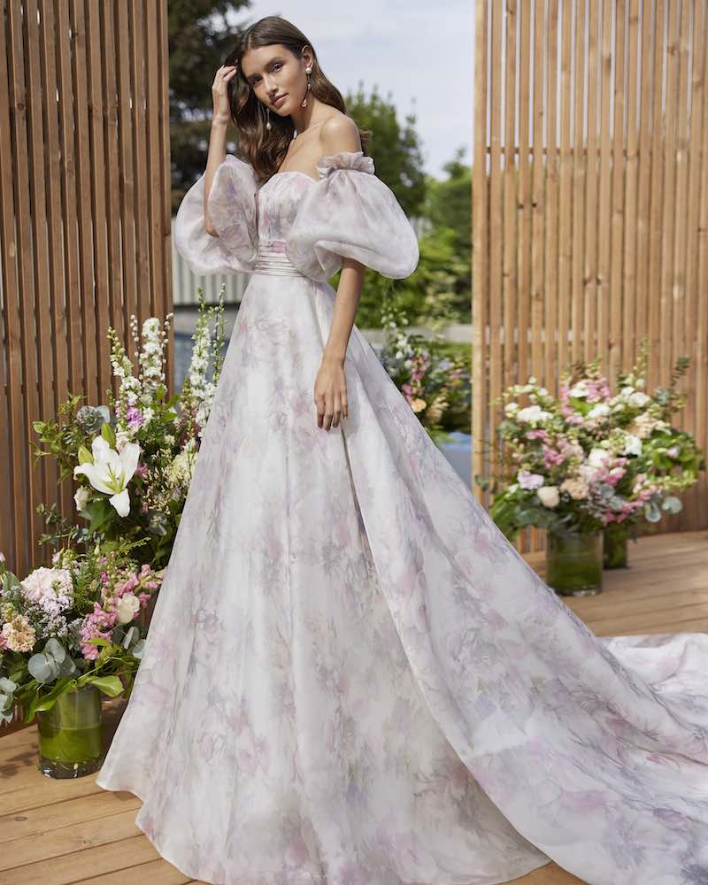 In questa foto una modella indossa un abito da sposa in organza stampata e maniche balloon di Rosa Clará