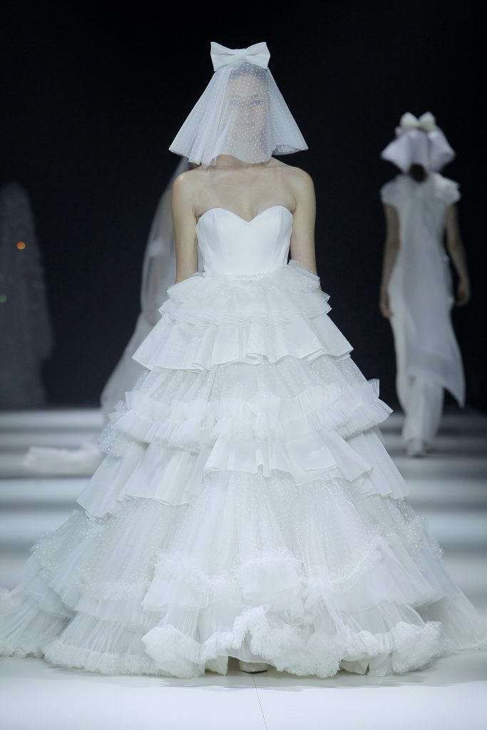 In questa foto la modella indossa un abito da sposa a principessa 2023 con balze di tulle