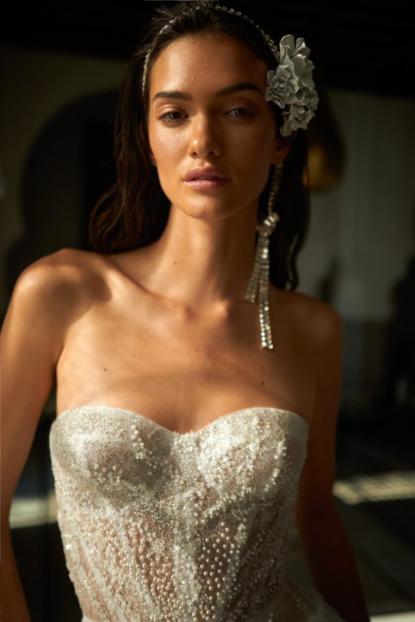 In questa foto, il primo piano di una modella che evidenzia così il bustier dell'abito da sposa Inbal Dror 2023 che indossa