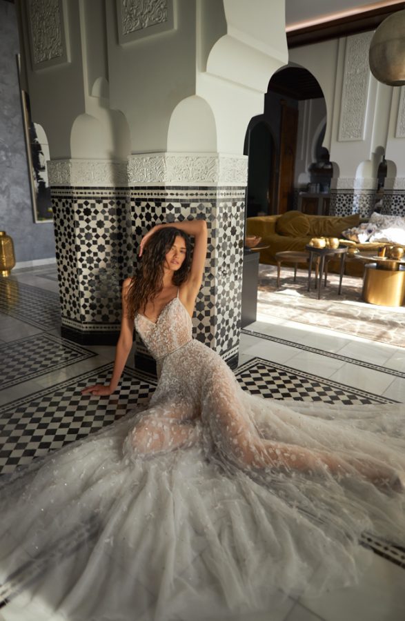 In questa foto una modella seduta per terra indossa un abito da sposa Inbal Dror 2023