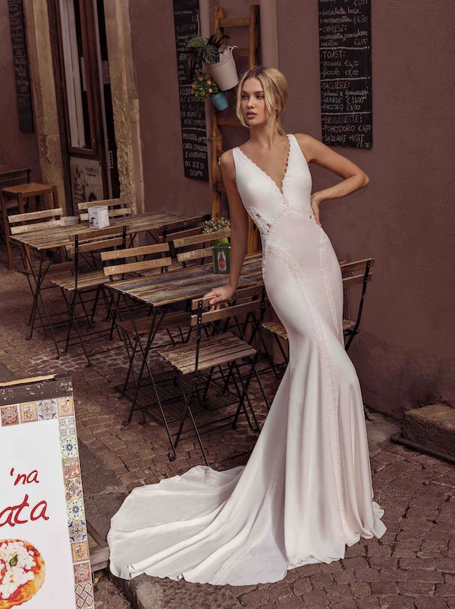 In questa foto, una modella posa indossando un abito da sposa skinny a sirena di modeca 2023
