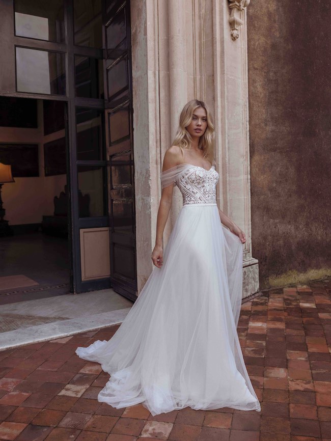 In questa foto una modella indossa un abito da sposa trasformabile Modeca 2023