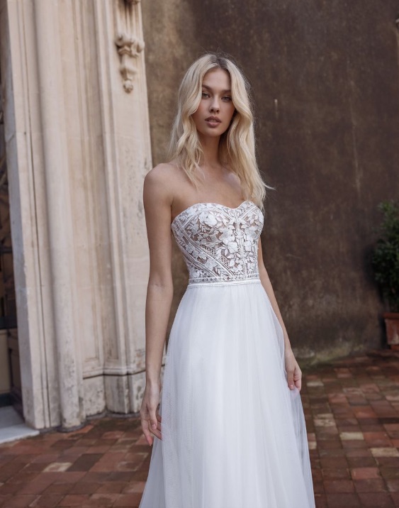 In questa foto la modella è ritratto con l'abito da sposa trasformabile della Revelation Collection 2023 senza le maniche, ma con bustier con scollo a cuore 