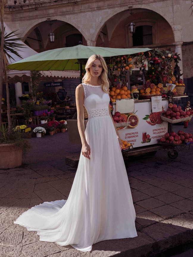In questa foto una modella con un abito da sposa scivolato Modeca 2023
