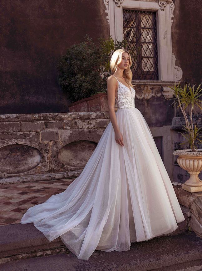 In questa foto una modella indossa un abito da sposa romantico 