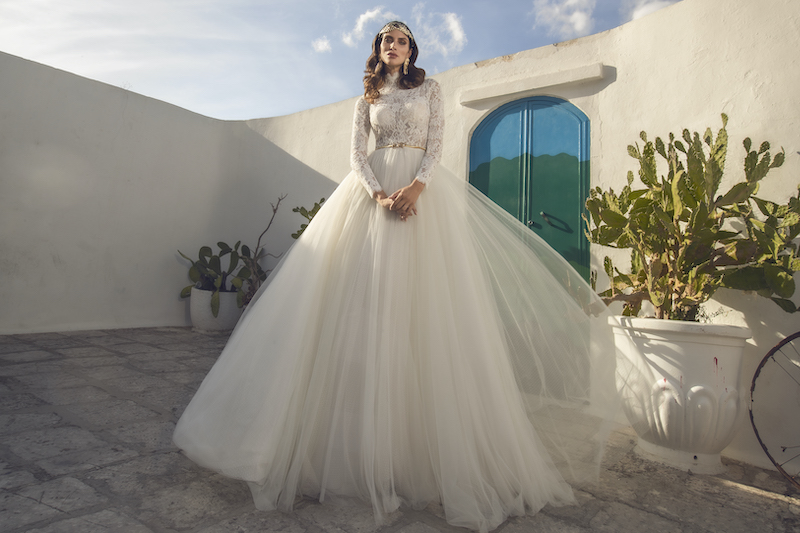 In questa foto una modella indossa un abito da sposa Pietro Demita Haute Couture 2023 con top con maniche lunghe e collo alto in pizzo all over e gonna vaporosa in tulle