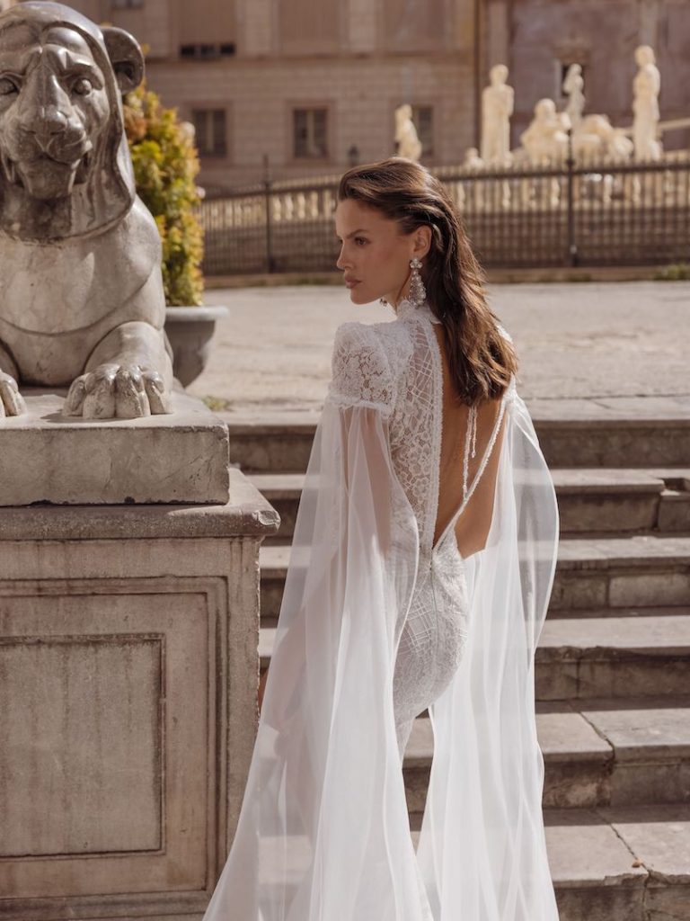 In questa foto una modella di spalle mostra la scollatura profonda e a V dell'abito da sposa che sta indossando