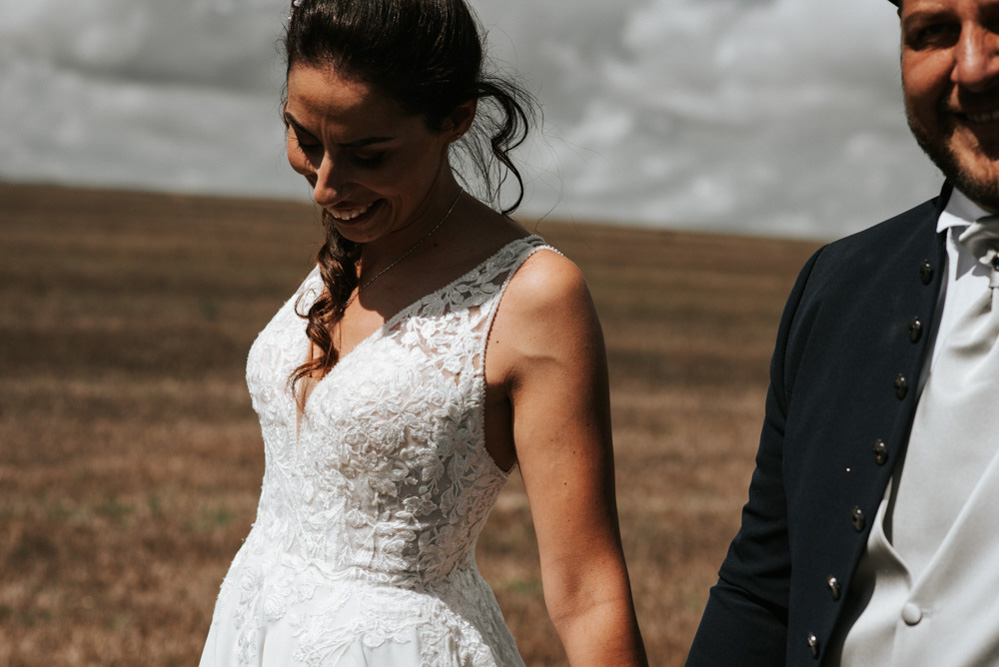 In questa foto un ritratto di due sposi sorridenti mentre si tengono per mano realizzato da Fabrizio Musolino, fotografo di matrimonio 