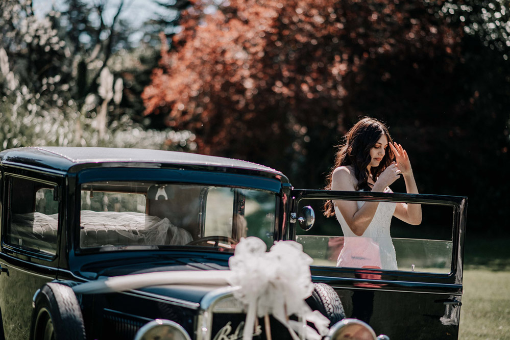 In questa foto, realizzata dal fotografo di matrimonio Fabrizio Musolino, una sposa esce dall'auto nuziale 
