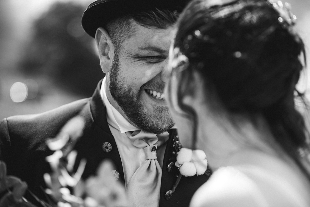 In questa foto in bianco e nero, realizzata da Fabrizio Musolino fotografo di matrimonio uno sposo sorride alla sua sposa