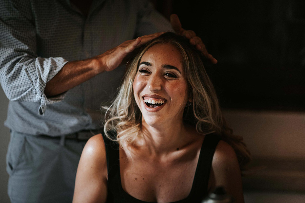 In questa foto i preparativi di matrimonio di una sposa sorridente che ha scelto Fabrizio Musolino