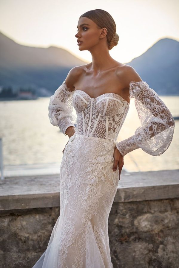 In questa immagine un abito da sposa del brand ucraino con decorazioni floreali all over