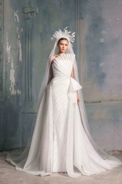 In questa foto una modella indossa un abito da sposa, con un dettaglio plissé e geometrico sul bustier, della collezione La Mariée 2023 di Tony Ward