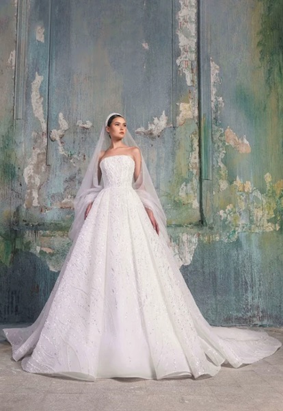 In questa foto una modella indossa un vestito da sposa con silhouette ad A, total white