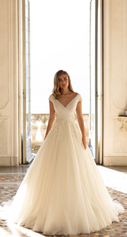 In questa foto una modella indossa un abito da sposa romantico della collezione Pollardi 2023