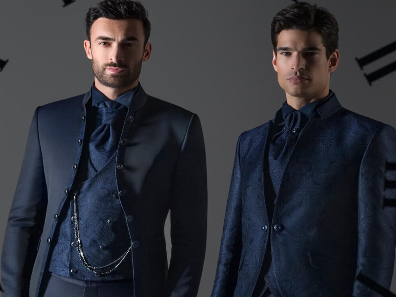 In questa foto due modelli indossano due abiti da cerimonia uomo della collezione Andrea Versali 2023