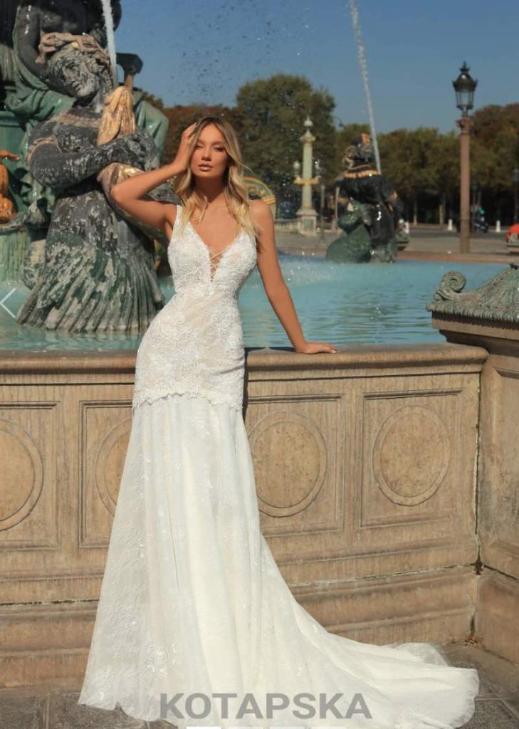 In questa foto una modella fotografata davanti ad una fontana a Parigi indossa un abito da sposa trasformabile a mezza sirena interamente in pizzo con coda di Iryna Kotapska