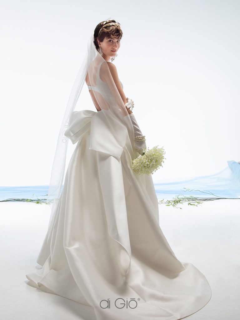 In questa immagine un abito da sposa con maxi fiocco sul retro Le Spose di Giò 2023.